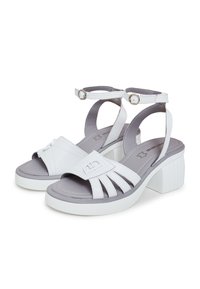 Sandali in finta pelle bianca con un accento grigio. Presentano una larga fascia, un design con fessure, una cinghia alla caviglia regolabile e un tacco a blocco bianco chunky.