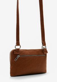 Borsa a tracolla in pelle marrone con finitura testurizzata, hardware argentato, tasca con zip e cinturino regolabile slim.