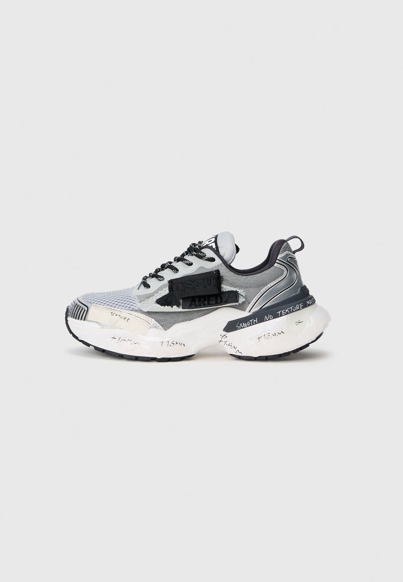 Sneakers chunky cu un superior din plasă gri și negru, talpă albă supradimensionată, șireturi negre și accente scrise de mână pe talpă pentru detalii.