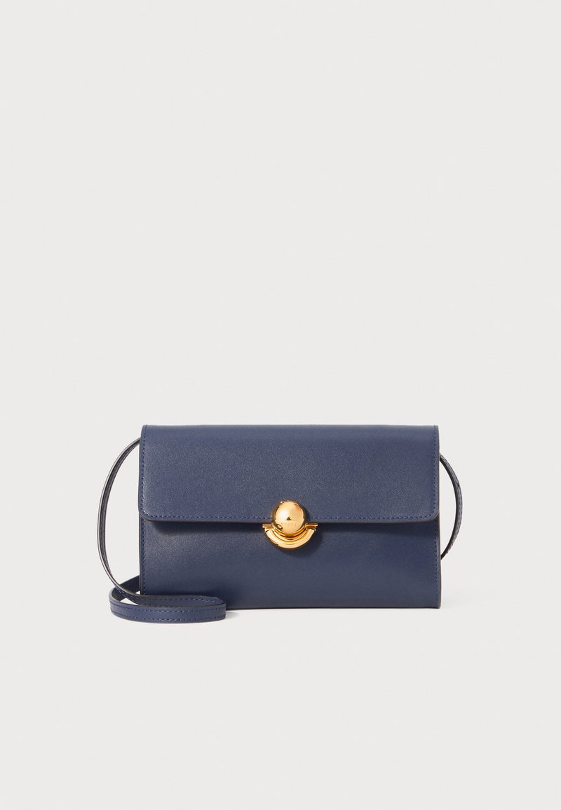 Navy leather handbag with a structured design, featuring a gold circular clasp and a detachable shoulder strap. Smooth texture and clean lines.
