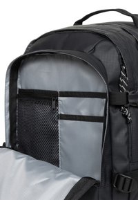 Czarna wnętrze plecaka z szarą podszewką. Zawiera siatkową kieszeń i dwie oddzielne komory. Gładka tkanina z trwałymi szwami.