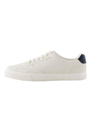 Biały niski sneaker z teksturowaną podeszwą, sznurowaniem z przodu i ciemną zakładką na pięcie na białym tle.
