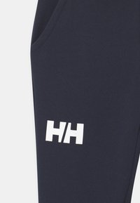 Granatowe spodnie dresowe z mieszanki bawełny, z boczną kieszenią i dużym białym logo "HH" nadrukowanym na lewym udzie.