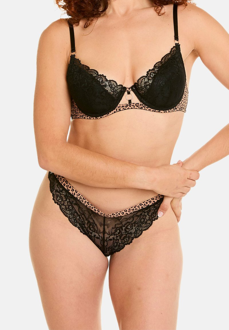 Soutien-gorge en dentelle noire avec une bande en imprimé léopard, doté de bords festonnés et d'un fermoir décoratif sur le devant. String en dentelle assorti avec des détails similaires.