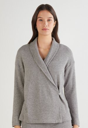 Cardigan gris à côtes avec un col châle, des manches longues et une fermeture à boutons sur le côté. Texture douce avec une coupe décontractée.
