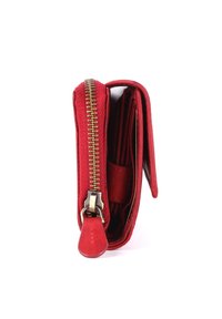 Cartera roja con exterior de lona, cierre de cremallera, herrajes dorados y múltiples compartimentos para tarjetas y efectivo. Textura suave.
