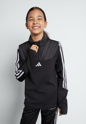 Zwarte sportieve pullover met hoge kraag, ritssluiting aan de voorkant, textuur aan de bovenkant, lange mouwen met drie witte strepen, gecombineerd met zwarte broek.