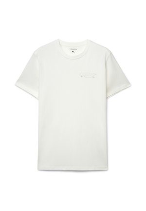 Biała bawełniana koszulka z krótkimi rękawami, okrągłym dekoltem i delikatną fakturą. Po lewej stronie znajduje się wytłoczony napis: "WORK HARD".