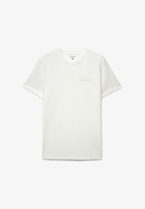 Biała bawełniana koszulka z krótkimi rękawami, okrągłym dekoltem i delikatną fakturą. Po lewej stronie znajduje się wytłoczony napis: "WORK HARD".