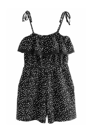 Combinaison noire sans manches avec motif de pois blancs irréguliers, encolure à volants, taille élastique et bretelles nouées aux épaules.