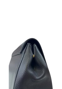 Borsa in pelle nera con superficie texturizzata, forma morbida e un piccolo dettaglio dorato vicino alla chiusura, caratterizzata da un design con cima arrotondata.