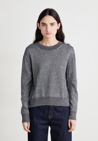 Pull gris métallique avec un col rond et un tricot texturé. Il possède des manches longues et des boutons décoratifs sur l'épaule gauche.