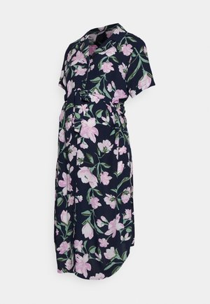 Mørkeblå graviditetskjole med korte ærmer, pink blomstermønster, krave og et matchende stofbælte bundet om taljen.