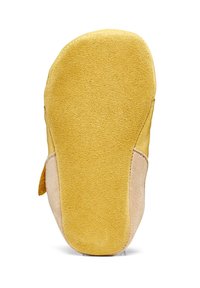 Geel suède schoenzool met een gladde textuur, met een ronde vorm en een beige accent aan één kant.
