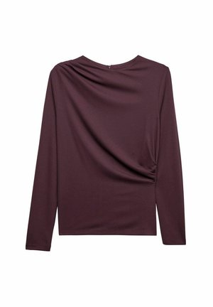 Långärmad topp i djup burgundyröd, tillverkad av slät tyg, med rynkad detalj på sidan och en cirkulär halsringning med en diskret dragkedja.