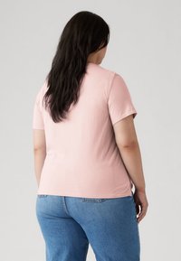 Ροζ κοντομάνικη μπλούζα, μαλακό υλικό, άνετη εφαρμογή, με στρογγυλή λαιμόκοψη. Συνδυάζεται με τζιν παντελόνι σε ανοιχτό μπλε.