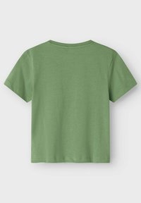 Camiseta verde de manga corta hecha de algodón suave. Presenta un cuello redondo y un diseño simple sin adornos ni gráficos. Textura suave.