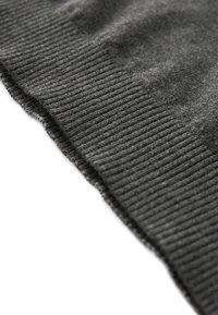 Tissu tricoté gris foncé avec bord côtelé, montrant une texture douce et duveteuse ainsi que des détails de couture fins.