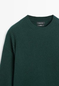 Grüner, gerippter Strickpullover aus 100 % Wolle. Mit Rundhalsausschnitt und eingesetzten Schultern. Sichtbares Etikett mit dem Markennamen "Massimo Dutti".
