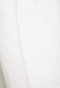 White fabric with smooth texture, showing a seam line running vertically near the left side.