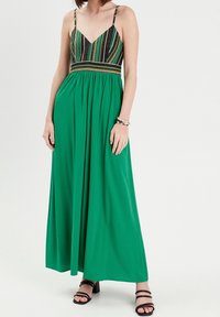 Maxi jurk met een v-hals en dunne bandjes, met een multicolore patroon op het lijfje en een vloeiende groene rok. Gladde stofstructuur.
