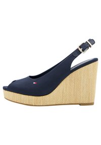Sandali wedge blu marina con punta aperta, tomaia in tessuto e base in paglia intrecciata. Presentano una fascetta slingback con dettagli in fibbia metallica.