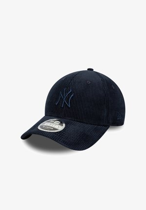 Casquette de baseball en velours côtelé bleu marine avec logo brodé, visière incurvée et sangle réglable. Présente une surface texturée et une étiquette de marque circulaire.