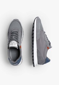Graue Sneaker aus Netz- und Wildledermaterialien, mit orangefarbenen und marineblauen Akzenten, einer weißen Zwischensohle und einer strukturierten schwarzen Laufsohle.