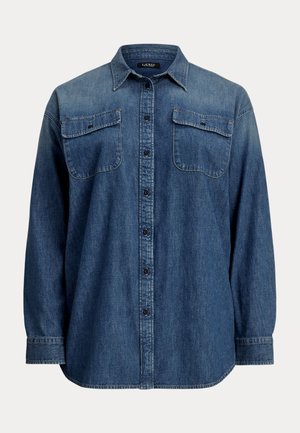 Camicia di denim di colore blu scuro con maniche lunghe, chiusura a bottoni, due tasche sul petto e colletto classico. Presenta una vestibilità rilassata e un orlo curva.