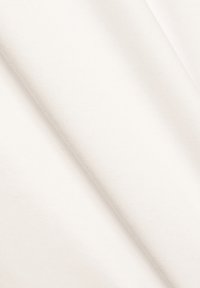 Biely, štruktúrovaný textil položený pod uhlom, ukazujúci hladký povrch a jemný vzor tkania, vhodný na rôzne textilné aplikácie.