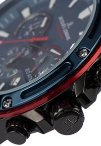 Herrklocka med en marinblå urtavla, röda accenter, klockhus av rostfritt stål och svart krona. Har tre subdials och en strukturerad bezel.