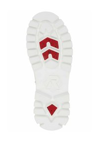 Semelle de chaussure en caoutchouc blanche avec des profondeurs de crantage, présentant des accents rouges en motif chevron et de petites speckles noires. Logo en relief au centre.