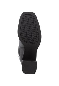 Suela de zapato negro de tacón con un patrón texturizado para agarre. El material parece estar gomoso, con un tacón plano y angular y un acabado suave.