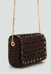 Sac à main tissé brun de forme rectangulaire, avec une bandoulière en chaîne dorée et des accents dorés le long des bords. Surface texturée avec un design décontracté.