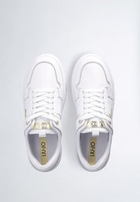 Sneakers in pelle bianca con dettagli dorati, punta tonda, design con lacci, collo imbottito e suola texture. La fodera interna presenta un marchio dorato.