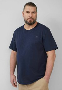 Navyblaues Baumwoll-T-Shirt mit kurzen  Ärmeln und rundem Halsausschnitt. Mit kleinem Logo auf der linken Vorderseite. Glatte Textur, lässige Passform.