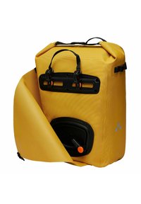 Mochila impermeable amarilla hecha de material texturizado con herrajes negros y una válvula naranja. Cuenta con asas en la parte superior y un cierre enrollable.