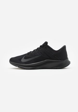 Zapatilla de running negra de corte bajo con parte superior de malla, cierre de cordones y suela gruesa y texturizada, mostrando el perfil lateral izquierdo sobre fondo blanco.
