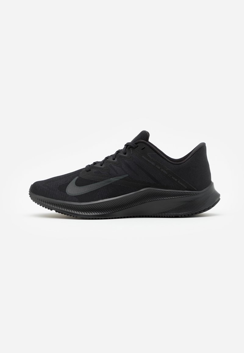 Chaussure de course basse noire avec dessus en mesh, fermeture à lacets et semelle épaisse texturée, montrant le profil gauche sur fond blanc.