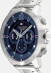 Montre en acier inoxydable argenté avec un cadran bleu, comportant trois sous-cadrans, des accents argentés et une étanchéité de 5 ATM.