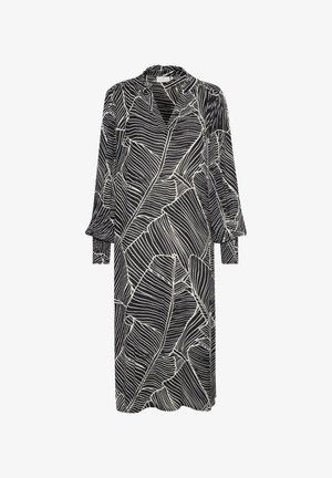 Črna obleka z belimi listnatimi vzorci, dolgi rokavi z manšetami, visok ovratnik in sproščen kroj. Tkanina ima gladko teksturo.