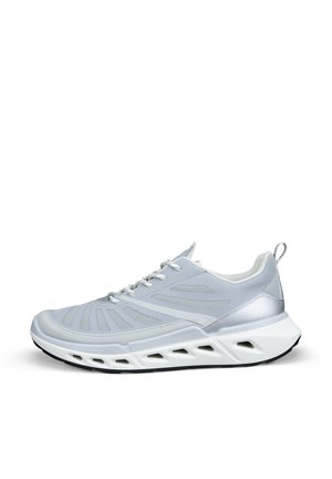 Sneaker sportiva grigio chiaro e bianco con pannelli in mesh, chiusura con lacci, collo imbottito e suola spessa con ritagli geometrici.