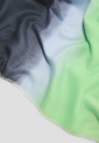 Zachte, lichte sjaal met een gradient ontwerp in zwart, blauw en felgroene kleuren, en franjes langs de randen.