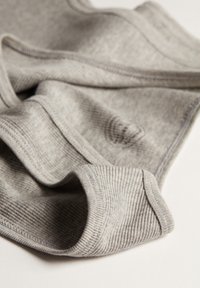 Tejido gris de canalé con una textura suave, que presenta bordes doblados y un patrón sutil, mostrando un diseño relajado y caído.