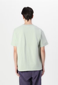 Mint green cotton t-shirt with short sleeves, crew neckline, and a relaxed fit. Smooth texture with minimal stitching details at seams.