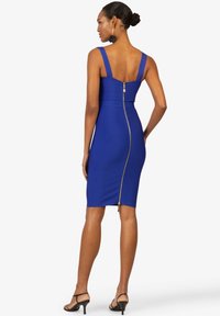 Klassisches royalblaues, tailliertes Kleid mit breiten Trägern und einem Reißverschluss auf der Rückseite. Der Stoff ist glatt und dehnbar, an den Körper angepasst für eine elegante Silhouette.