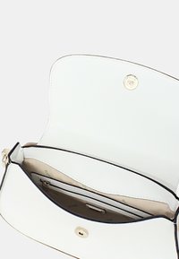 Piccola borsa bianca con esterno texturizzato, hardware dorato e chiusura magnetica, dotata di una tasca interna e foderata in beige.