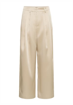 Beżowe spodnie typu wide-leg wykonane z gładkiego materiału, z plisami, elastycznym pasem i prostym krojem, bez widocznych kieszeni ani wzorów.