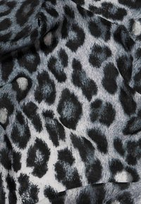 Must-hall ja hall leopardimustriga kangas, mis sisaldab tekstuuriga laikude mustrit pehme ja kerge materjaliga, millel on peened varjundid ja värvi erinevused.