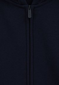 Mornarska zip-up kapuca, izdelana iz mehkega blaga. Ima osrednji zadrgo s oznako "BLUE RIDGE", rebraste manšete in spodnji rob ter gladko teksturo.